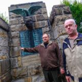 Nico Heinemann (l.) und Gregor Bomholt von der Bürgerschützengilde Röllinghausen-Berghausen zeigen, wo einst die Kupferplatten am Ehrenmal an der Ortlohstraße in Recklinghausen hingen