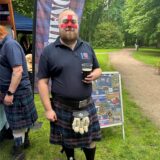 Mann im Schottenrock mit Bierglas und bemaltem Gesicht