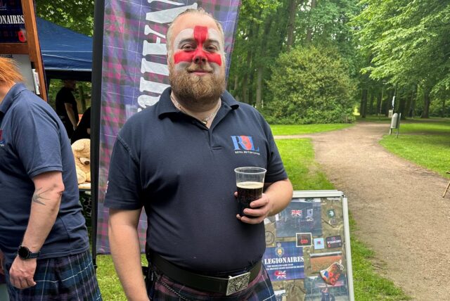 Mann im Schottenrock mit Bierglas und bemaltem Gesicht