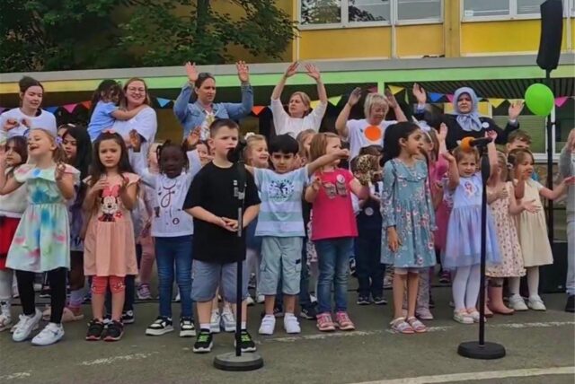 Kinder auf dem Hof der Kita Artikus beim Singen.