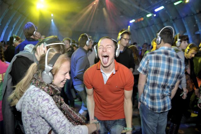 Disco-Besucher mit Kopfhörern auf den Ohren.