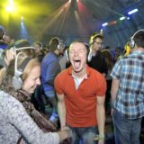 Disco-Besucher mit Kopfhörern auf den Ohren.