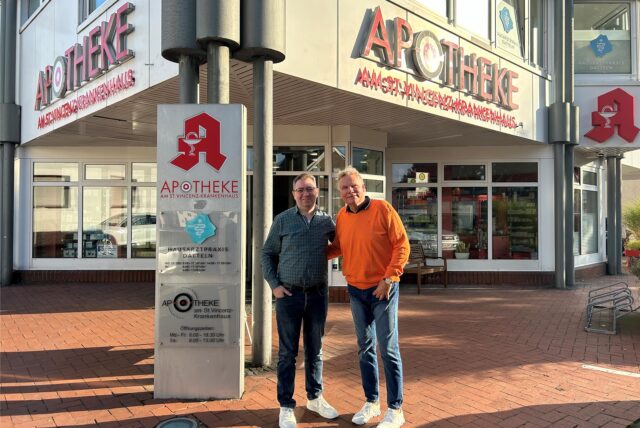 George Daye und Joachim Kraneis stehen vor der Apotheke am St. Vincenz-Krankenhaus.