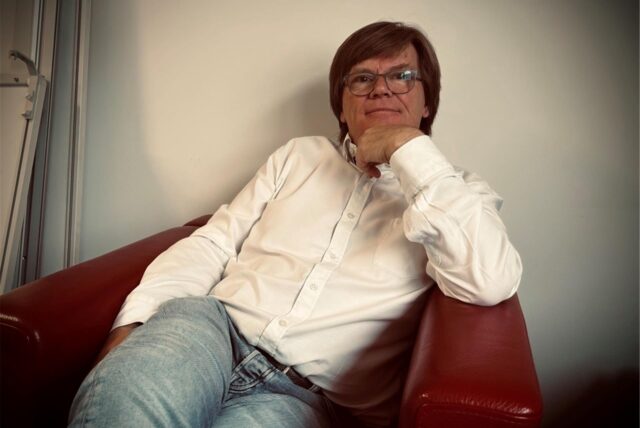 Dag Hagby sitzt in seinem Büro bei der eqs GmbH in Dortmund in einem roten Sessel.