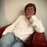 Dag Hagby sitzt in seinem Büro bei der eqs GmbH in Dortmund in einem roten Sessel.