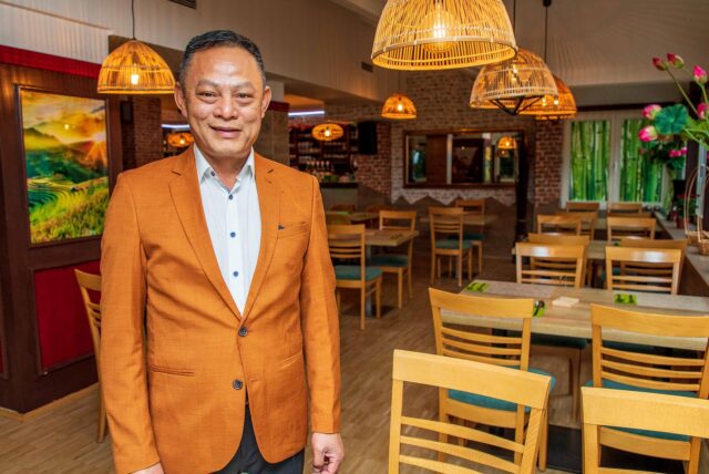 Hai Vu steht neben den Tischen in seinem Restaurant Bep Viet.