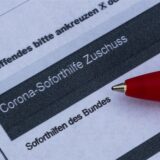 Ein Stift liegt auf einem Antrag für den Corona-Soforthilfe-Zuschuss.