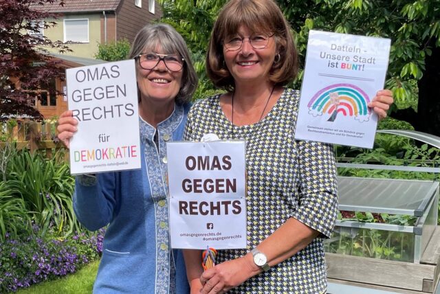 Marion Schmilgus und Sylvie Roland-Grützner halten Plakate hoch mit den Aufschriften „Omas gegen rechts für Demokratie“ und „Datteln – unsere Stadt ist bunt“.