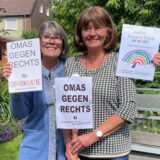 Marion Schmilgus und Sylvie Roland-Grützner halten Plakate hoch mit den Aufschriften „Omas gegen rechts für Demokratie“ und „Datteln – unsere Stadt ist bunt“.