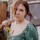 Die Singer-Songwriterin Slaughterin Daisies hält eine Axt in der Hand, sie steht beim Auftakt der Sparkassen-Clubraum-Contests im Treffpunkt Altstadt auf der Bühne.