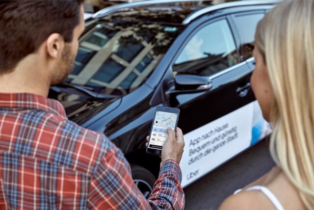 Zwei Personen buchen eine Uber-Fahrt über die App von dem Fahrtvermittlungsservice den es seit einem halben Jahr in NRW, unteranderem in Dortmund gibt.