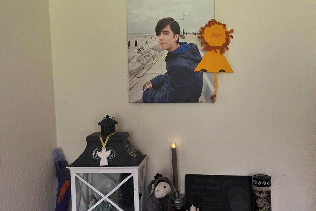 An dieser Wand und in vielen anderen Bereichen der Wohnung erinnern Bilder an Elias, der auch nach seinem Tod weiterhin ein Teil der Familie bleibt.