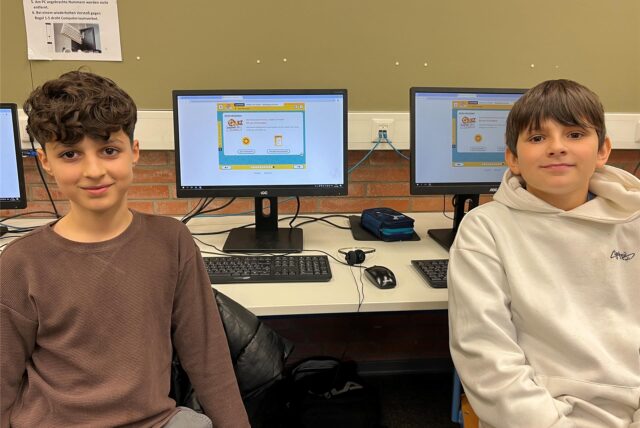 Hammo und Ben vor Computern im Computerraum.