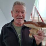 Gerhard Bretscher steht in einem Treppenhaus und hält den Pilz in die Kamera.