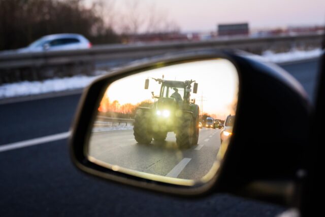Ein Traktor spiegelt sich in einem Rückspiegel.