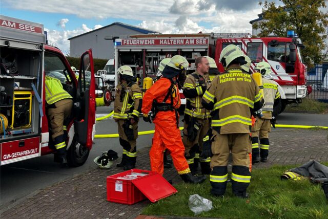 Feuerwehrleute legen einen Spezialanzug an.