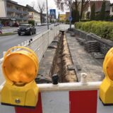 Eine Baustelle: Am Fahrbahnrand sind Baustellenabsperrungen aufgestellt die einen Graben direkt am Rand des Bürgersteiges umzäunen.