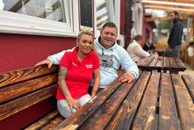 Dimitra Georgiou und Timur Ratzer sitzen am Tisch auf der Terrasse des neueröffneten Grillhauses Hades.
