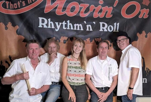 Die Band Movin’On steht und sitzt vor einem Banner mit der Aufschrift „Movin’On – Rhythm’n’Roll“.