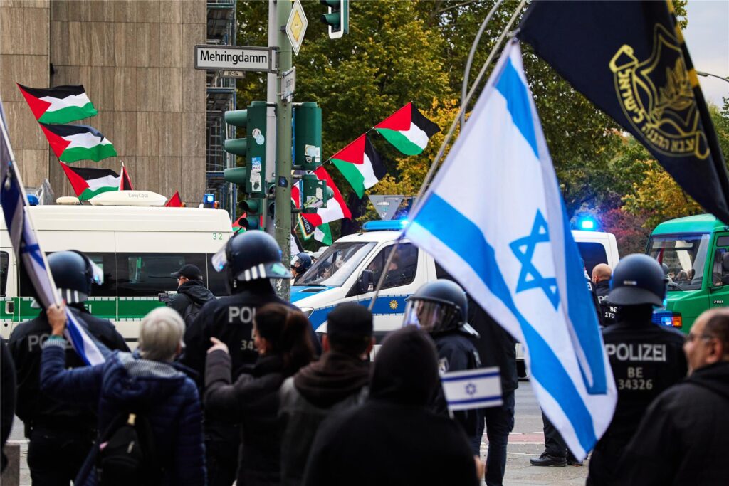 Teilnehmer einer proisraelischen Demonstration (vorne) als Gegenveranstaltung einer propalästinensischen Demonstration anlässlich des ersten Jahrestages des Überfalls der Hamas auf Israel halten an der Ecke Mehringdamm/Blücherstraße israelische Flaggen. Teilnehmer einer proisraelischen Demonstration (vorne) als Gegenveranstaltung einer propalästinensischen Demonstration anlässlich des ersten Jahrestages des Überfalls der Hamas auf Israel halten an der Ecke Mehringdamm/Blücherstraße israelische Flaggen.