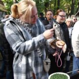 Auf dem Arm einer Besucherin der Hertener Erntedankfestes sitzt eine Eule, die von der Frau gestreichelt wird.