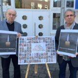 Dr. Mark Gutkin (links), Vorsitzender der Jüdischen Gemeinde Recklinghausen, und Vorbeter Isaac Tourgman stehen vor der Synagoge. Zwischen ihnen steht eine Staffelei mit einer Collage der beim Überfall der Hamas auf Israel entführten Personen. In den Händen halten die beiden Männer Bilder einer Kerze, darunter steht #RememberOctober7.