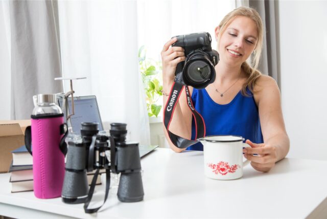 Eine Frau fotografiert eine Kaffeetasse.