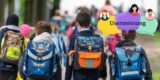 Jungen mit Schulranzen von hinten fotografiert.