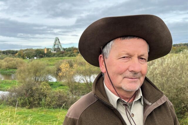 Ranger mit großem Hut, im Hintergrund der ehemalige Schacht AV 8