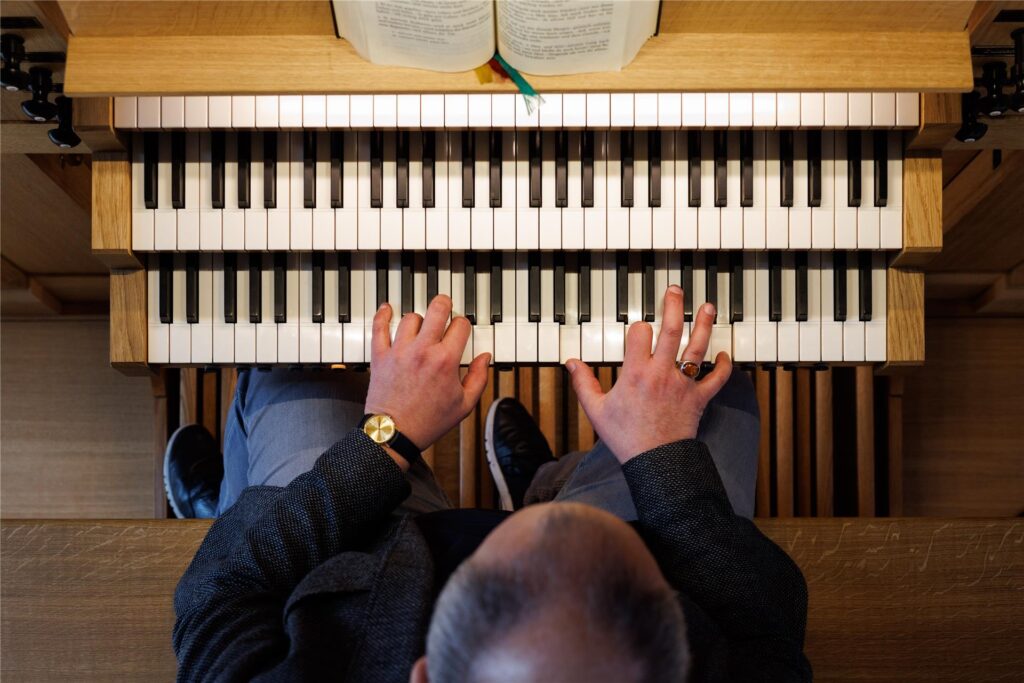Ein Mann sitzt an einer Orgel und spielt. (Symbolbild)