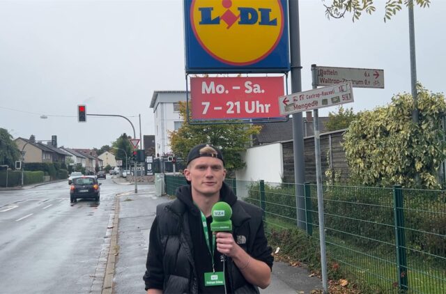 Johannes Wenzel von der Waltroper Zeitung mit Mikrofon vor der LIDL-Filiale in Waltrop.