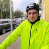 Patrick Berner steht mit Fahrradhelm und grüner Jacke auf dem Bürgersteig.