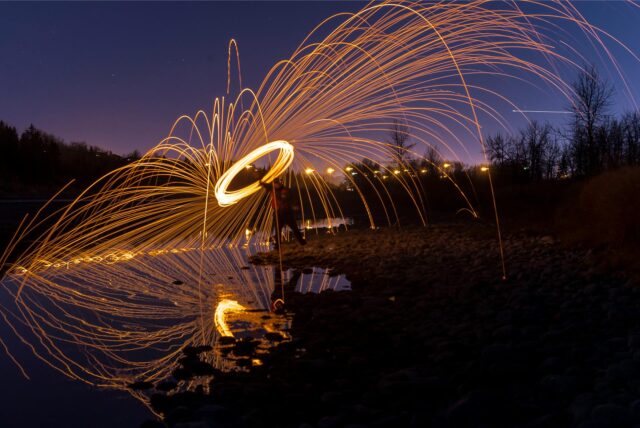Ein Foto im Dunkeln, auf dem Lichter durch Langzeitbelichtung Spuren hinterlassen.