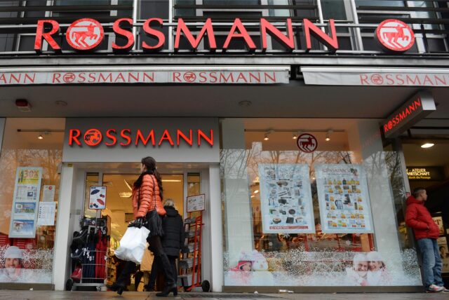 Eine Frau geht an einer Rossmann-Filiale vorbei.