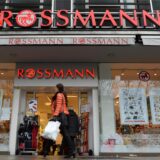 Eine Frau geht an einer Rossmann-Filiale vorbei.
