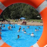 Blick durch einen Schwimmring auf die Besucher im Schwimmbecken des Freibards Hardenberg in Dortmund-Deusen.