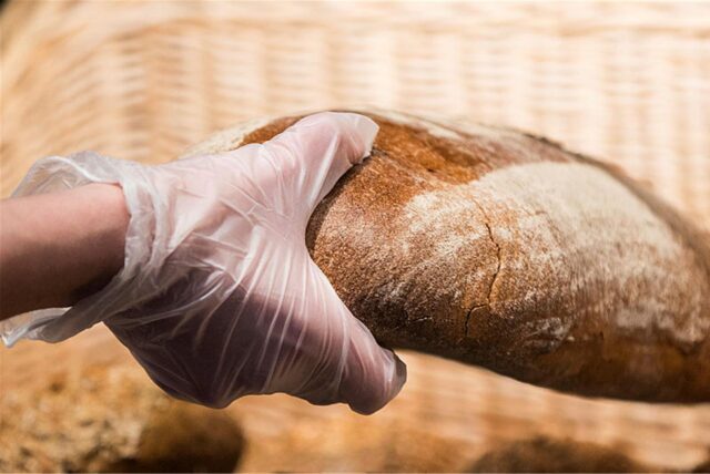 Eine Hand hält ein Laib Brot