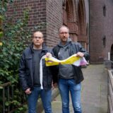 Tobias Ahlendorf vom Kirchenvorstand der Heilig-Kreuz-Gemeinde (links) und Studierendenpfarrer Dr. Simon Schwamborn (KHG) fanden von der Regenbogenfahne an der Heilig-Kreuz-Kirche nur noch einen Fetzen Stoff.