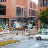 Die Baustelle der Hertener Höfe: Große Gebäude, von außen verklinkert, umlagert von mehreren Baggern und anderen Baumaschinen.