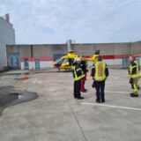 Ein Rettungshubschrauber auf einem Parkdeck in Datteln, davor stehen Feuerwehrleute.