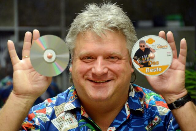 Ein Mann, der CDs hochhält.