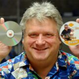 Ein Mann, der CDs hochhält.