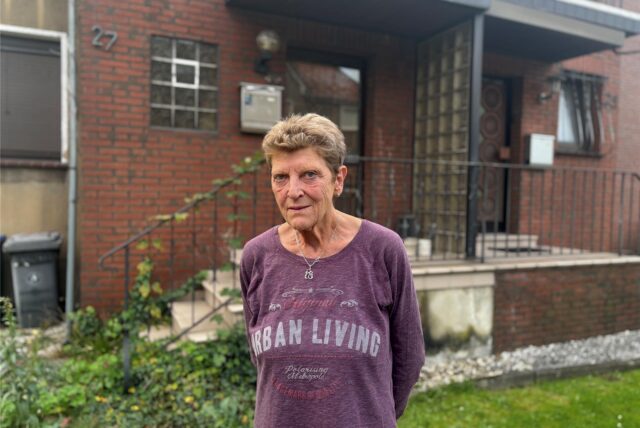 Gabriele Budka war eng mit den Bewohnern des Hauses befreundet, das nun zwangsversteigert wird. Sie hat uns die Geschichte über den Verfall des Grundstücks erzählt. Auf dem Bild steht Budka vor dem Haus mit der Nummer 27.
