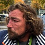 Kontra sitzt am Dortmunder Hauptbahnhof und blickt nach rechts.
