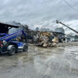 Ein Radlader des THW sowie eine Drehleiter der Feuerwehr stehen bereit, um den Brand beim Raiffeisen-Markt in Hünxe unter Kontrolle zu bringen.