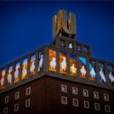 Am U-Turm bei Nacht zeigen Bildschirme Bilder von Tauben.