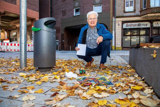 Bernd Lekse zeigt in der Hertener Innenstadt, dass Unrat neben einem Mülleimer liegt.