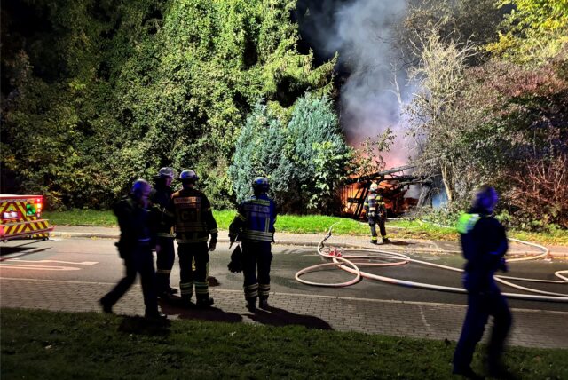 Einsatzkräfte der Feuerwehr beim Brand einer Gartenlaube in Dortmund.