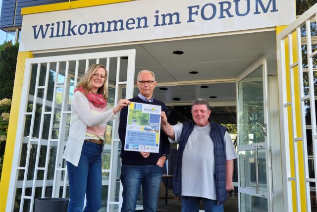 Drei Personen stehen vor einem Eingang