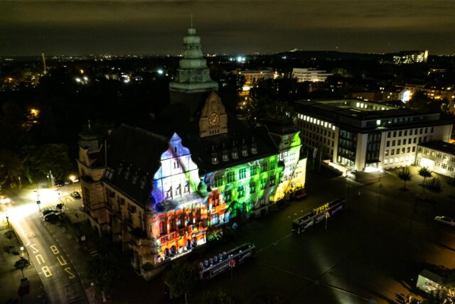 Das bunt beleuchtete Rathaus von Recklinghausen aus der Vogelperspektive.